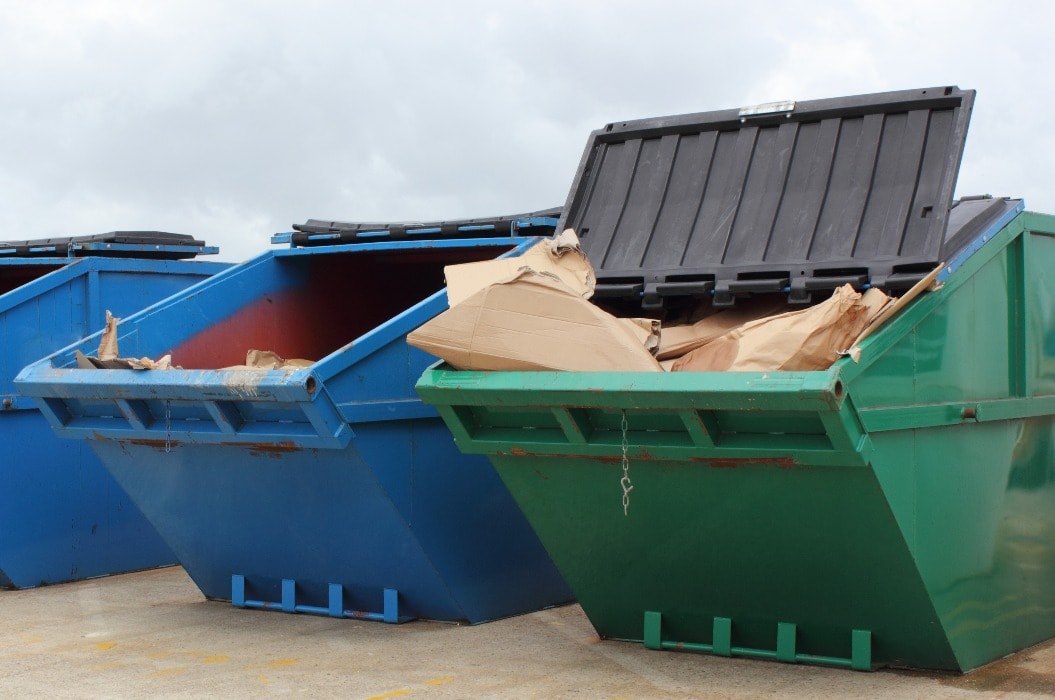 Drei große Abfall-Container befüllt mit Müll