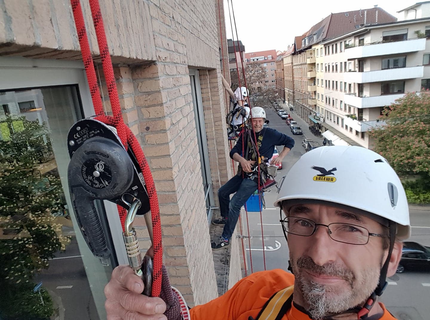 Reinigungsteam gesichert an der Hausfassade